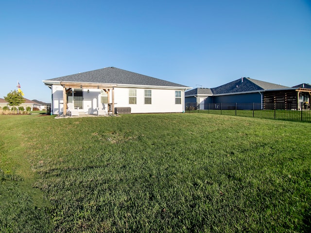 rear view of property featuring a patio and a yard