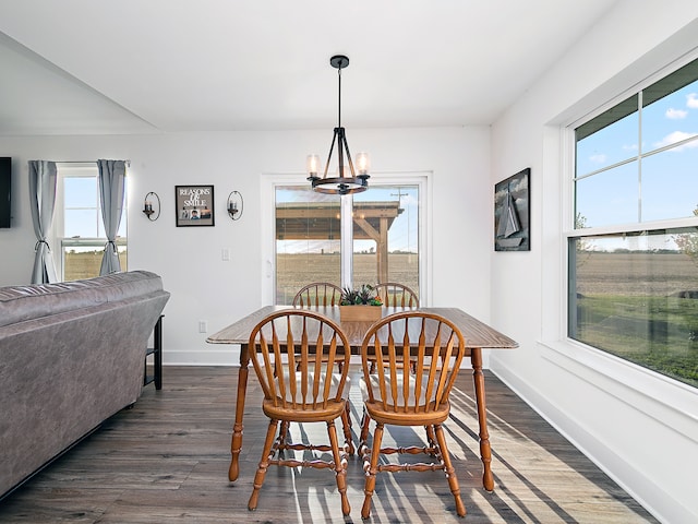 dining space featuring an inviting chandelier and dark hardwood / wood-style flooring