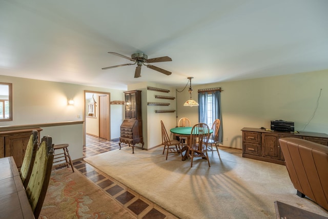 carpeted dining room featuring ceiling fan
