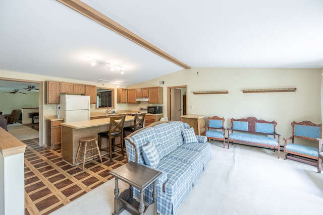 living room with vaulted ceiling with beams, dark colored carpet, ceiling fan, and sink