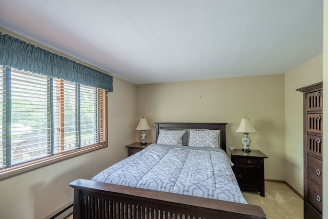 bedroom with light carpet and baseboard heating