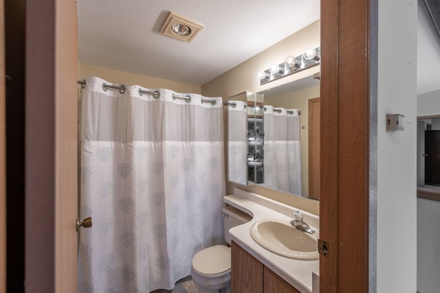 bathroom with walk in shower, vanity, and toilet
