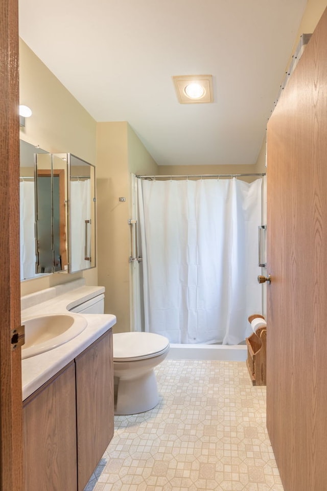 bathroom featuring a shower with shower curtain, vanity, and toilet