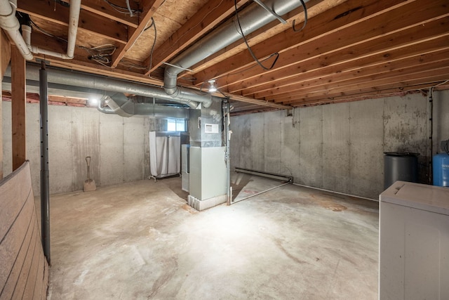 basement featuring heating unit and washer / dryer