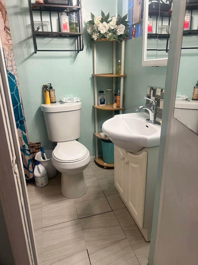 bathroom featuring vanity, a shower with curtain, toilet, and tile patterned flooring