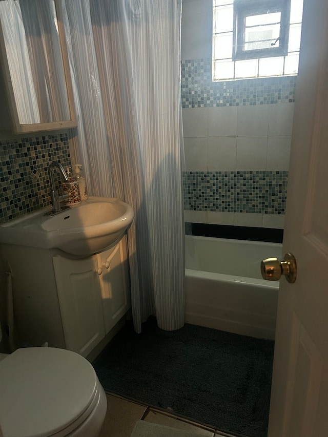 full bathroom with decorative backsplash, shower / bath combo, toilet, vanity, and tile walls