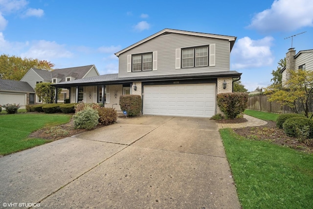 traditional home featuring brick siding, driveway, a front yard, and fence