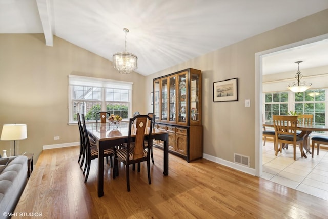 dining room featuring a wealth of natural light, visible vents, lofted ceiling with beams, and an inviting chandelier