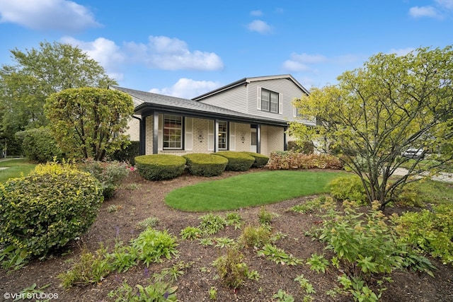 view of front of house featuring brick siding and a front yard