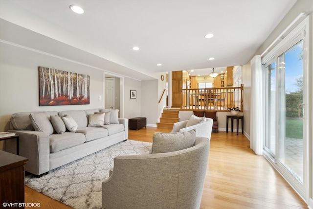 living room with recessed lighting, baseboards, stairs, and light wood-style floors