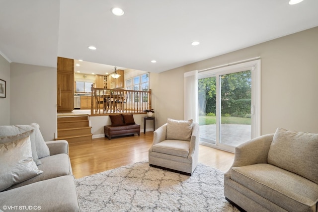 living area featuring light wood finished floors, a chandelier, recessed lighting, and baseboards