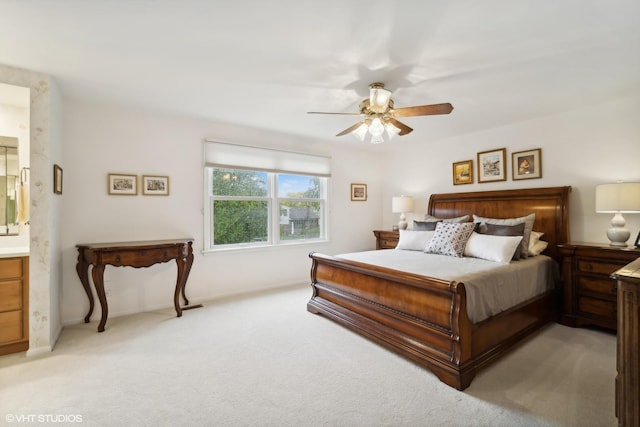 bedroom with light carpet, ceiling fan, and ensuite bathroom