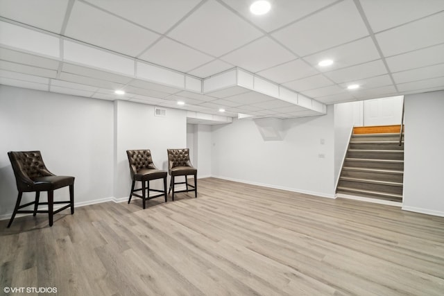 sitting room with visible vents, stairs, baseboards, and wood finished floors