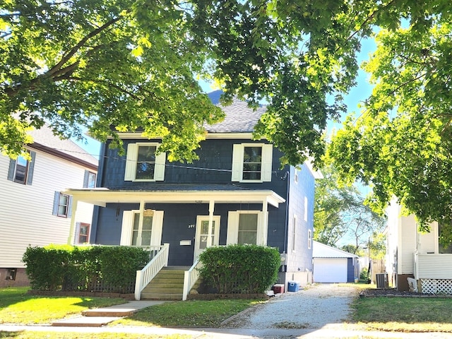 view of front of home with an outdoor structure, a front lawn, a garage, covered porch, and central AC unit