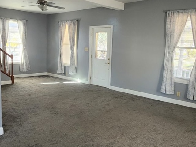 carpeted empty room with beamed ceiling and ceiling fan