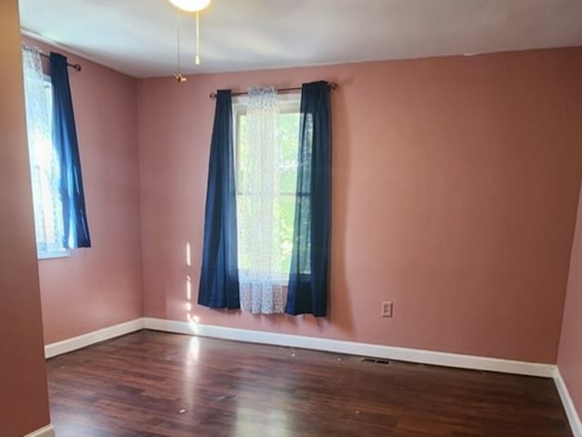 spare room with ceiling fan and dark hardwood / wood-style flooring