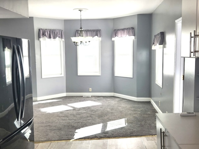 unfurnished dining area with light carpet and an inviting chandelier