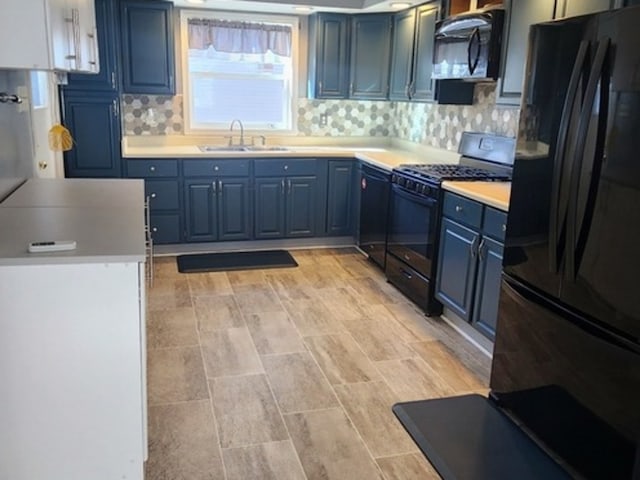 kitchen featuring decorative backsplash, light hardwood / wood-style flooring, sink, black appliances, and blue cabinetry