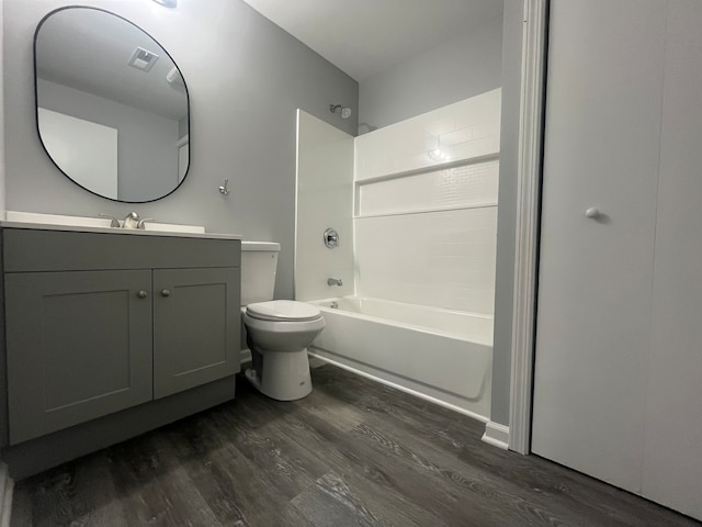 full bathroom featuring washtub / shower combination, hardwood / wood-style flooring, vanity, and toilet