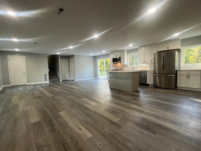 interior space with a kitchen island, dark hardwood / wood-style floors, white cabinets, sink, and appliances with stainless steel finishes