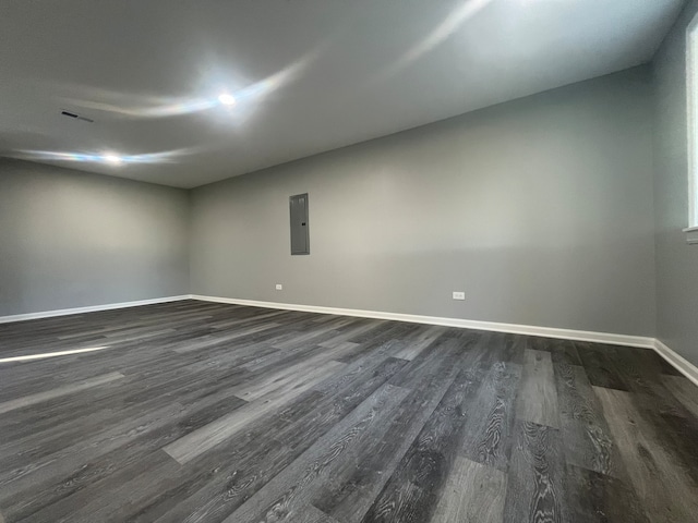 unfurnished room featuring electric panel and dark hardwood / wood-style flooring