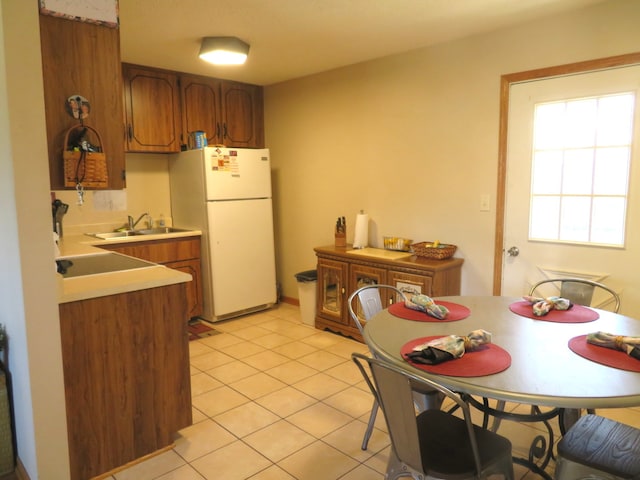 kitchen with sink, white fridge, and light tile patterned floors