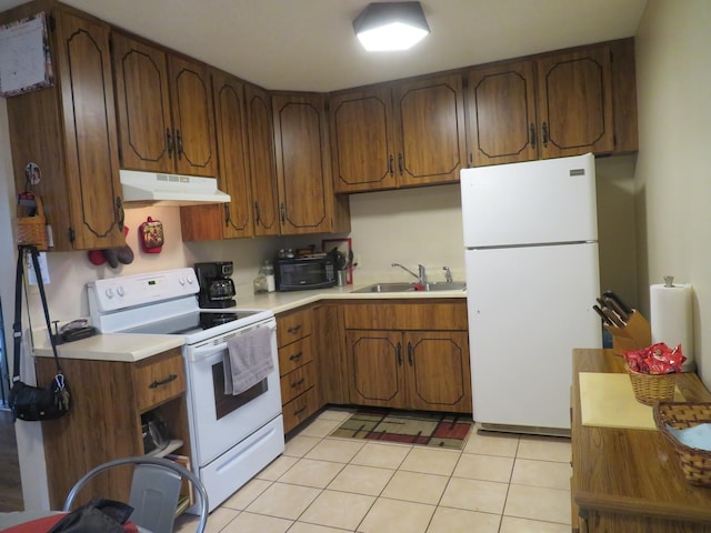 kitchen with light tile patterned floors, white appliances, and sink