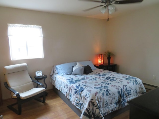 bedroom with wood-type flooring, a baseboard radiator, and ceiling fan