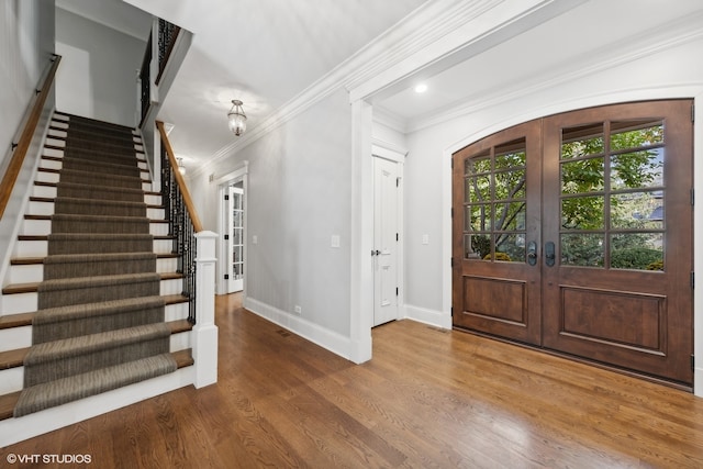 entryway with crown molding, french doors, and hardwood / wood-style flooring