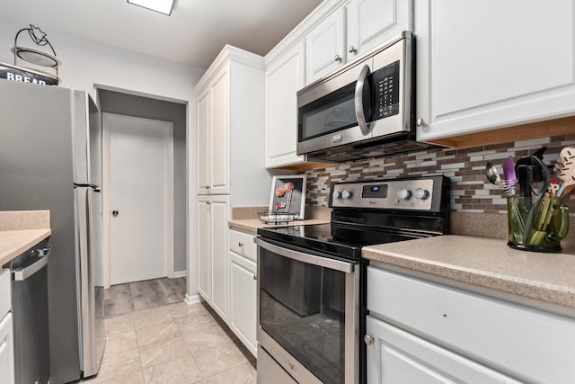 kitchen featuring white cabinets, stainless steel appliances, and tasteful backsplash