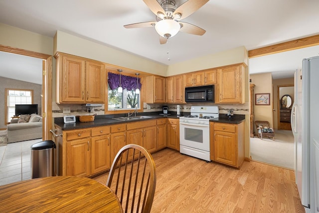 kitchen featuring ceiling fan, sink, white appliances, light hardwood / wood-style flooring, and decorative backsplash