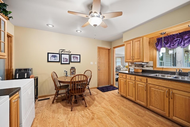 kitchen featuring light wood-type flooring, ceiling fan, sink, and washer / clothes dryer