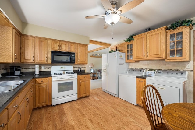 kitchen featuring white appliances, light hardwood / wood-style flooring, independent washer and dryer, sink, and backsplash