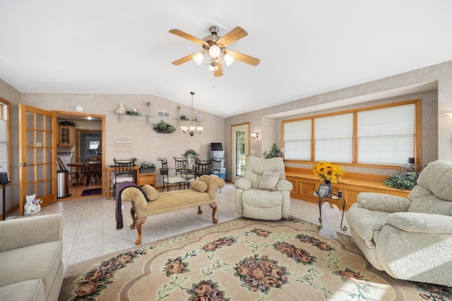 tiled living room with ceiling fan with notable chandelier and vaulted ceiling