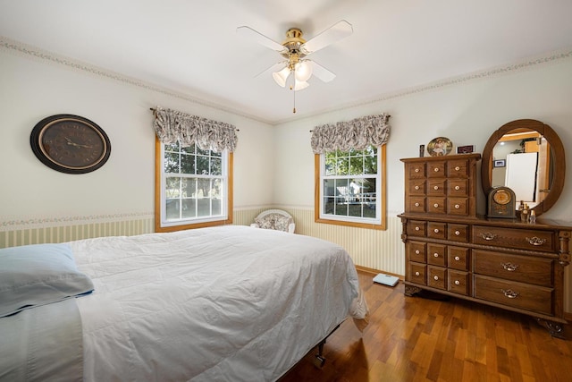 bedroom featuring ceiling fan, crown molding, and wood-type flooring