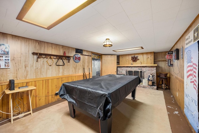 recreation room featuring a brick fireplace, pool table, wood walls, and carpet