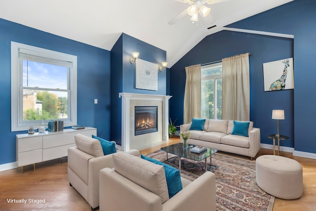 living room with vaulted ceiling, light hardwood / wood-style flooring, and plenty of natural light