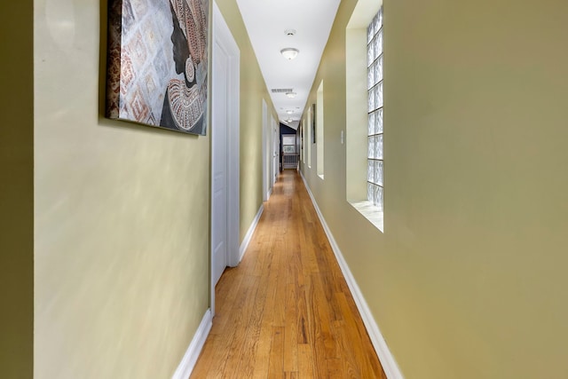 hallway with light hardwood / wood-style floors