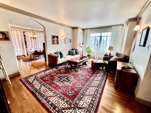 living room with an inviting chandelier, hardwood / wood-style flooring, and ornamental molding