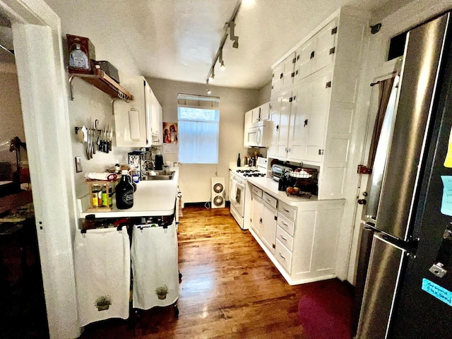 kitchen with sink, white appliances, wood-type flooring, and white cabinets