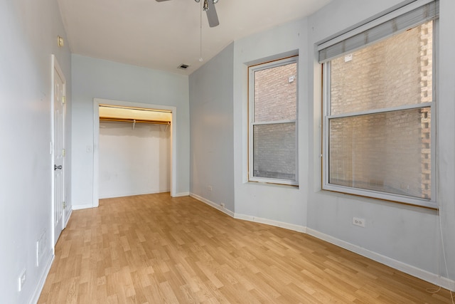 unfurnished bedroom featuring ceiling fan, a closet, and light hardwood / wood-style flooring