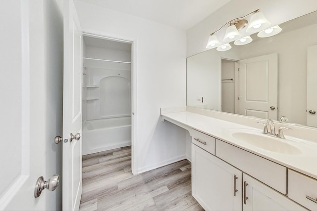 bathroom featuring vanity, hardwood / wood-style flooring, and shower / washtub combination