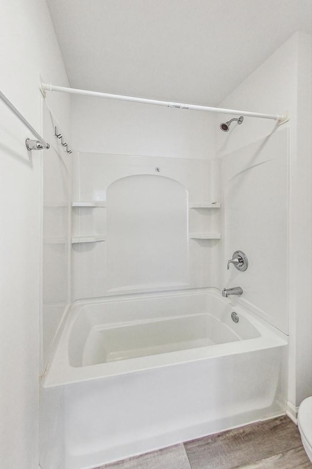 bathroom featuring toilet, tub / shower combination, and hardwood / wood-style floors