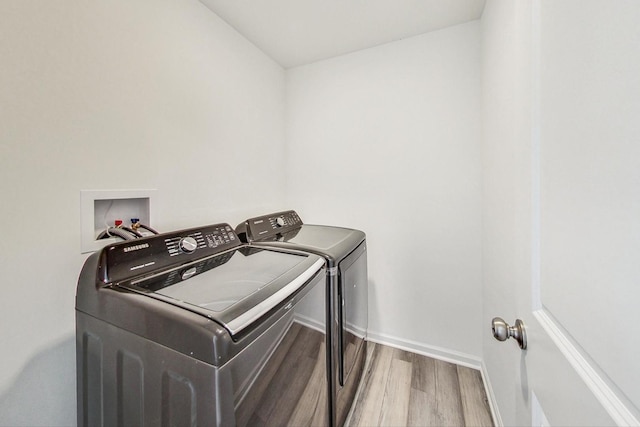 washroom featuring wood-type flooring and washer and clothes dryer