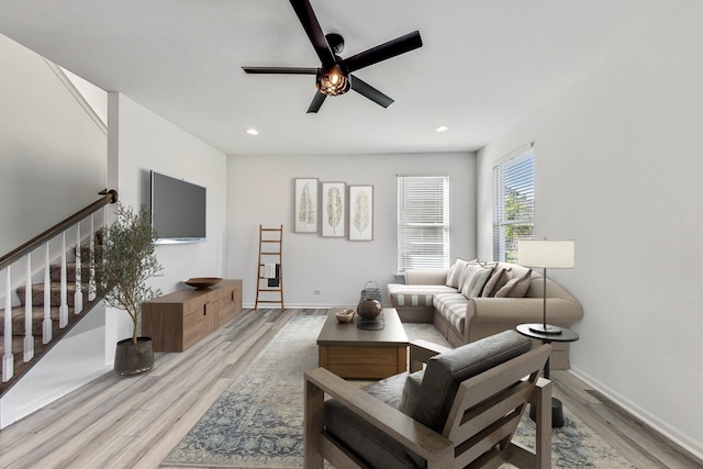 living room with light hardwood / wood-style flooring and ceiling fan