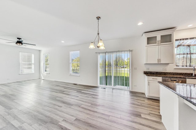 kitchen featuring white cabinetry, light hardwood / wood-style flooring, a wealth of natural light, and pendant lighting