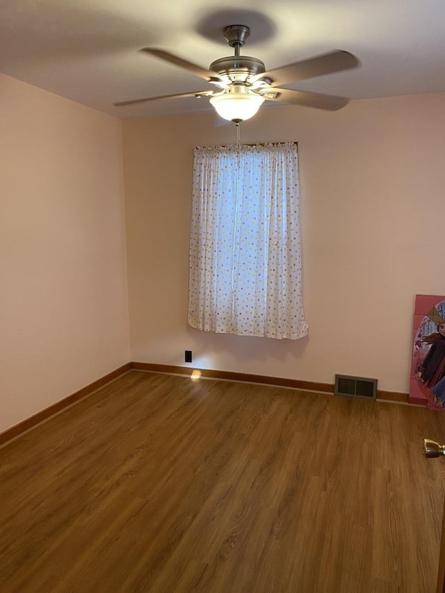 empty room with ceiling fan and hardwood / wood-style flooring