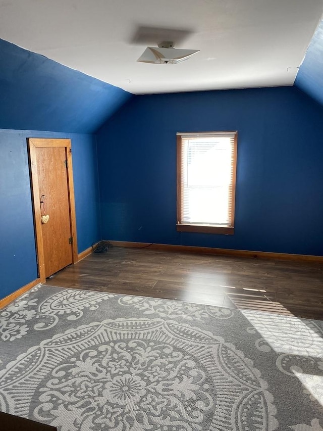 additional living space featuring vaulted ceiling and dark hardwood / wood-style floors