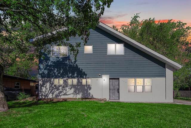 back house at dusk with a yard