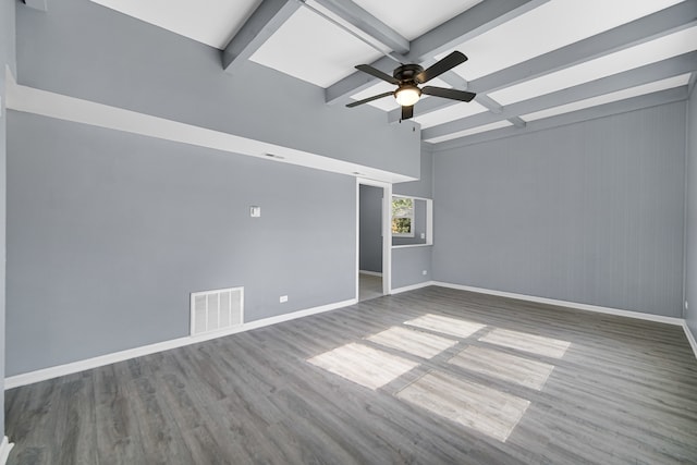 spare room with ceiling fan, wood walls, hardwood / wood-style floors, and beam ceiling